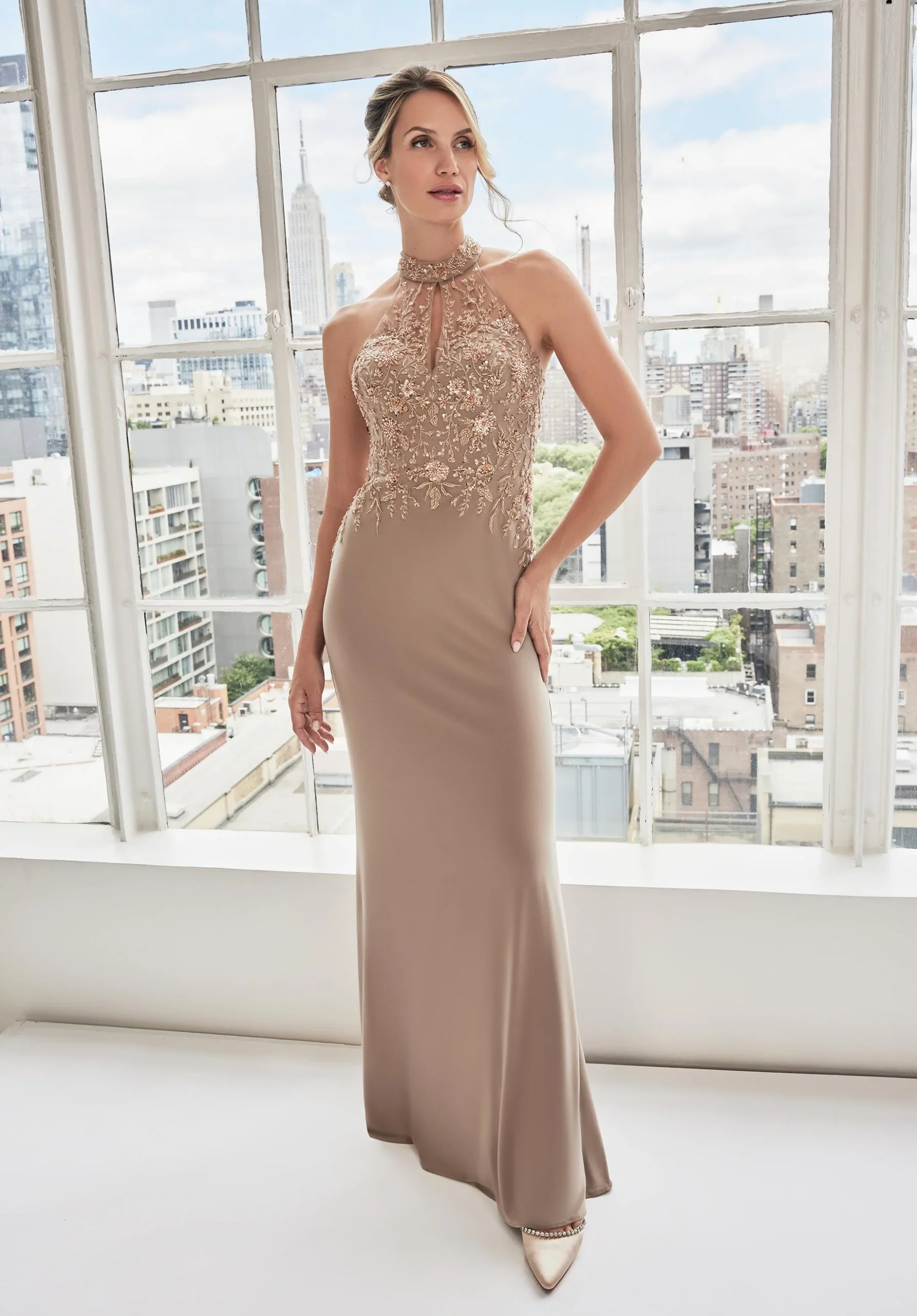 Elegant beige evening gown with sheer keyhole halter neckline and floral beaded bodice.