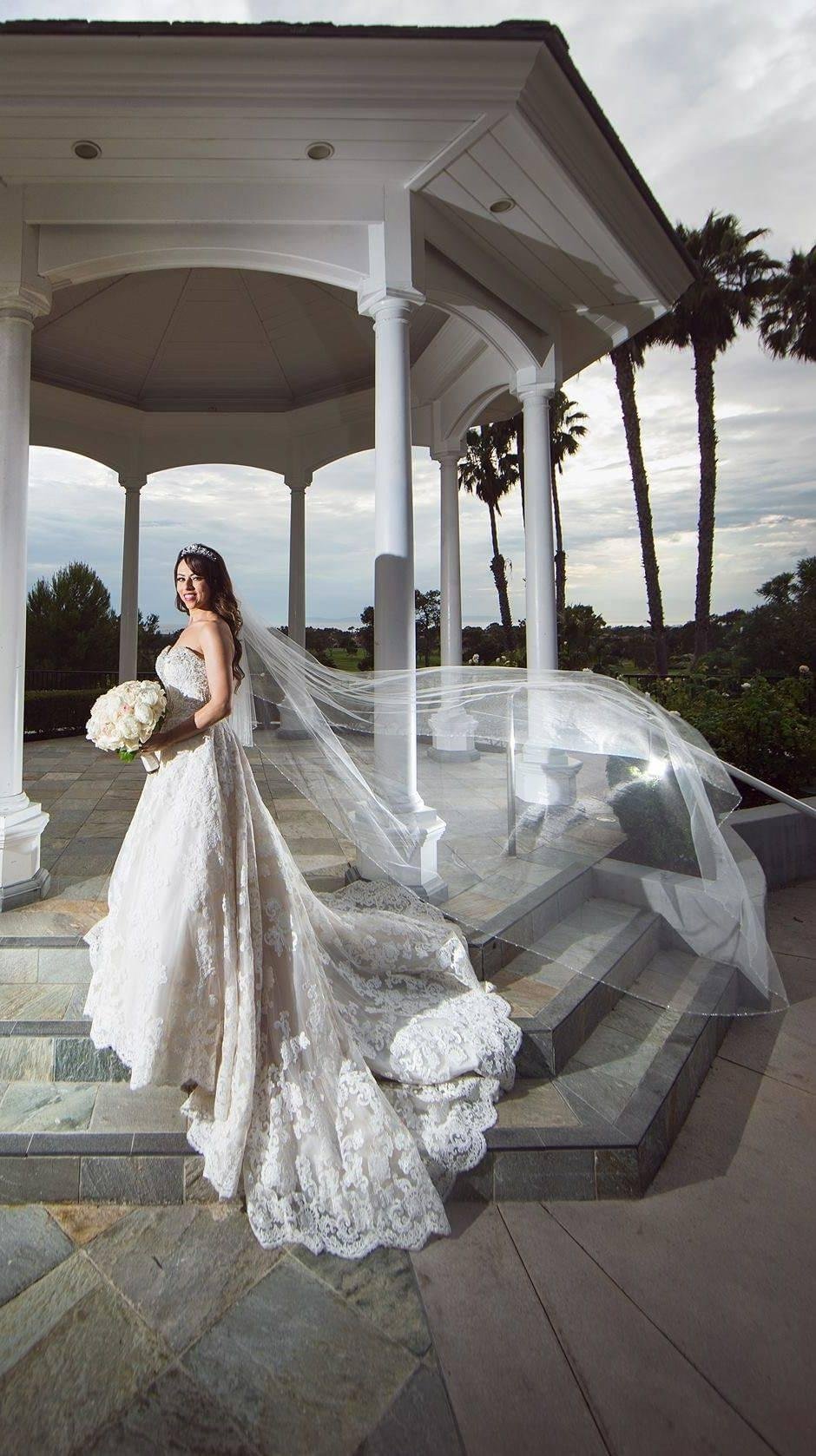a girl in white bridal dress giving a pose to camera man with a bokeh in her hand